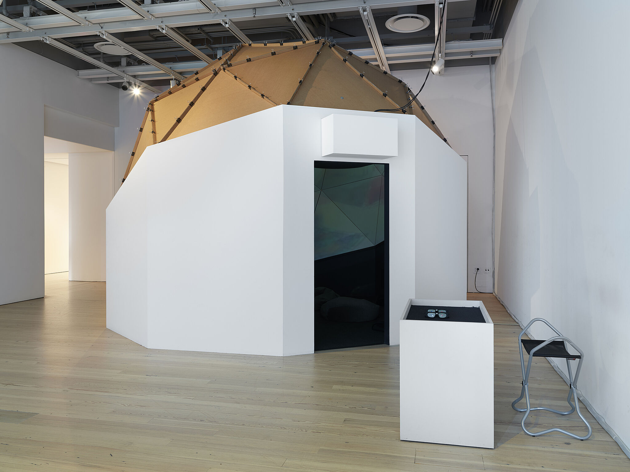 A doorway looking into a domed artwork in a gallery.