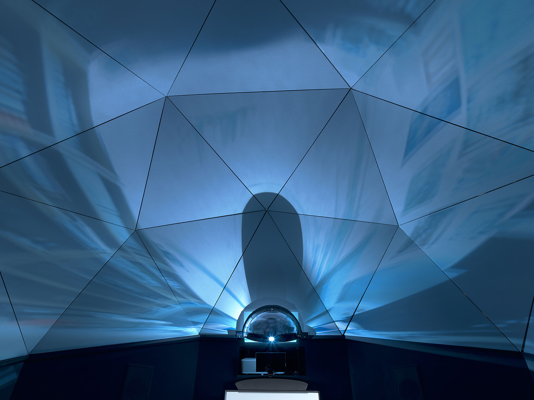 Looking up at the ceiling of a domed artwork with a video screen.