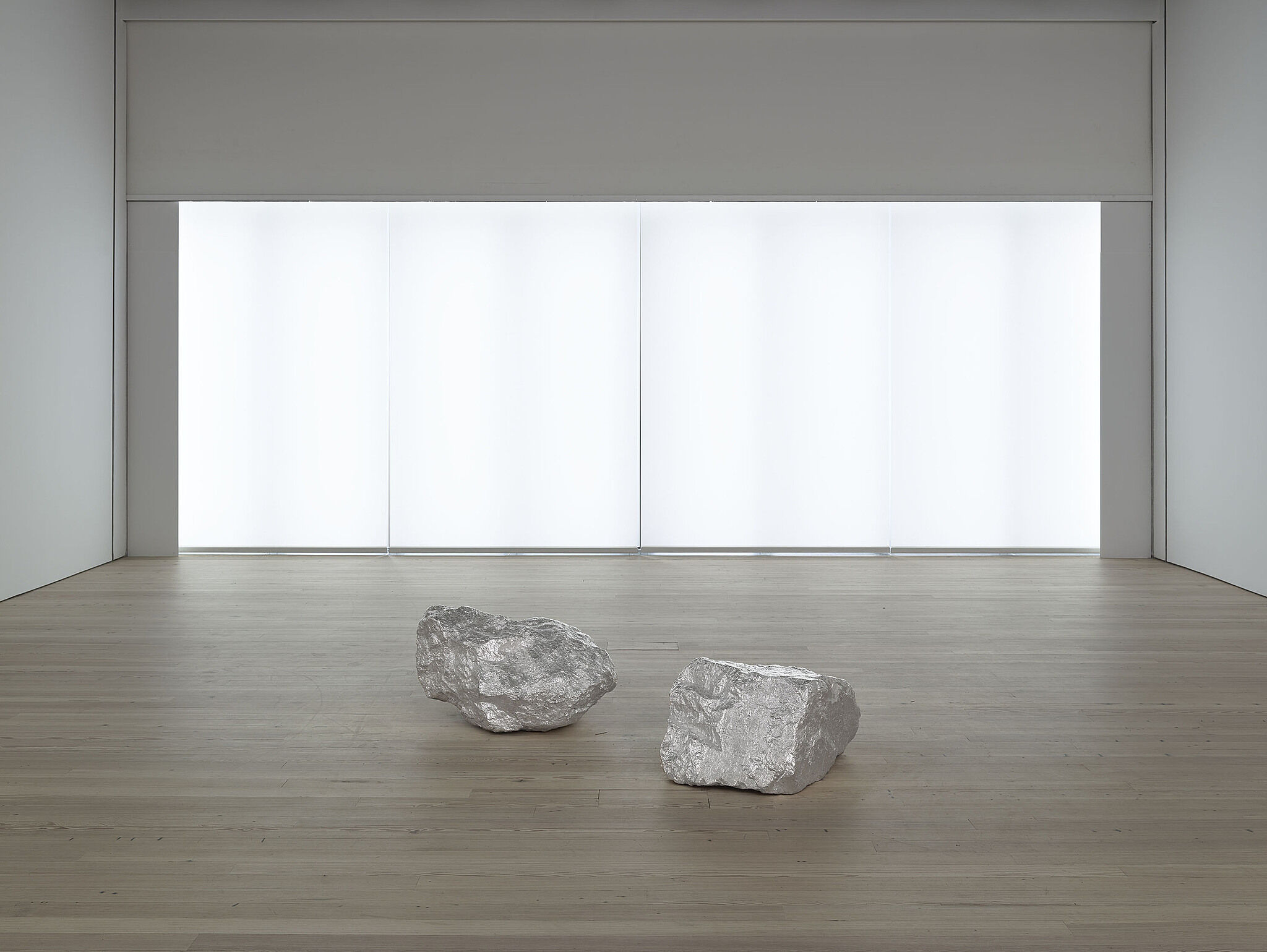 Two rocks  in the middle of a room with a bright light behind.