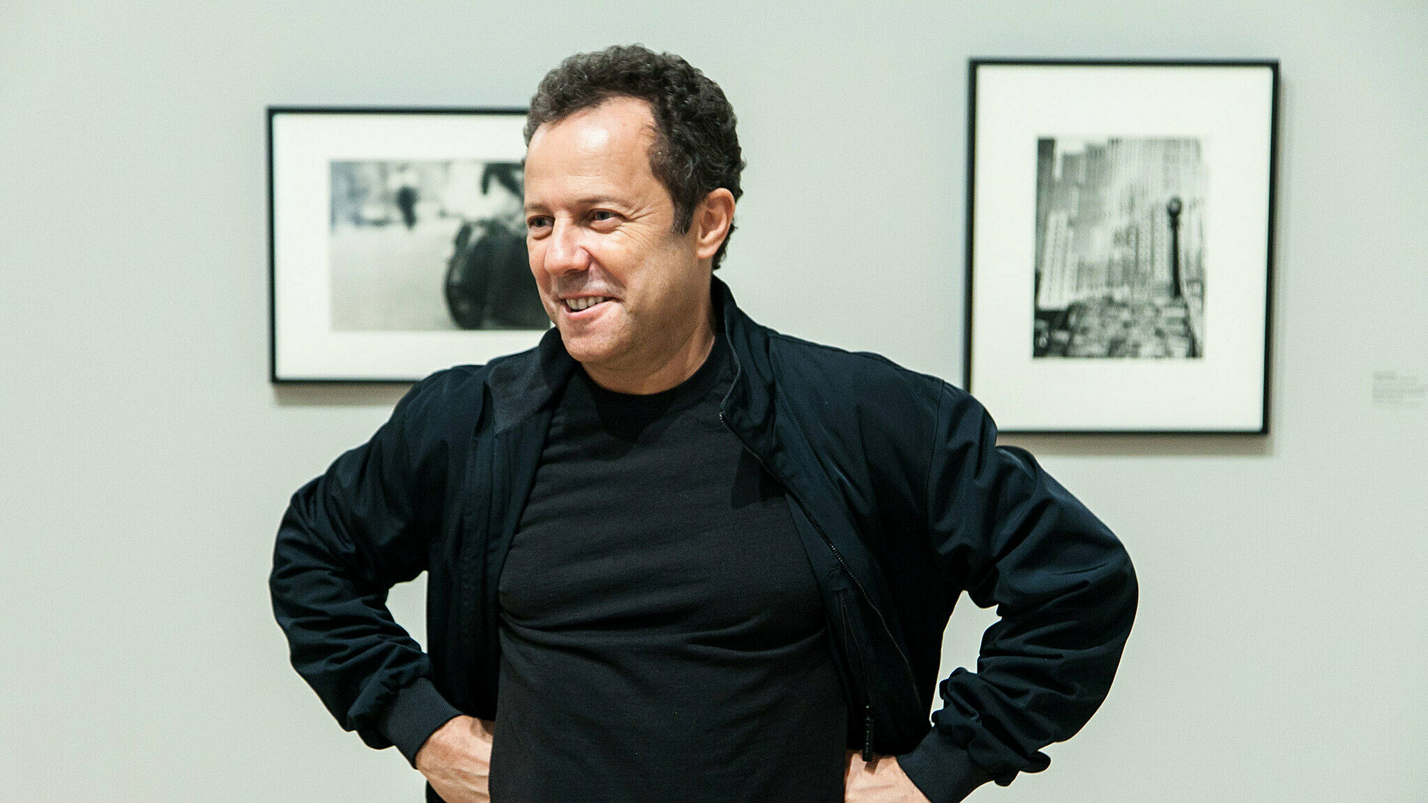 Victor Muniz poses in front of photos.