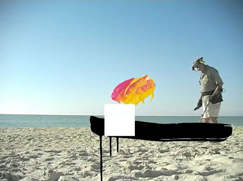 Film still of man on a beach.