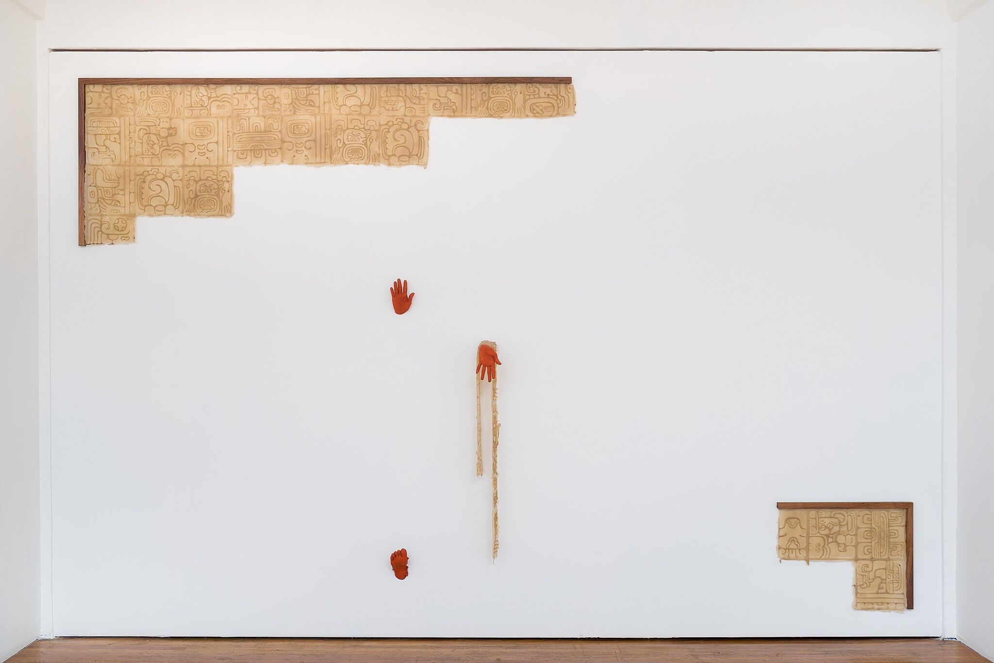 Orange hands emerging from a wall.