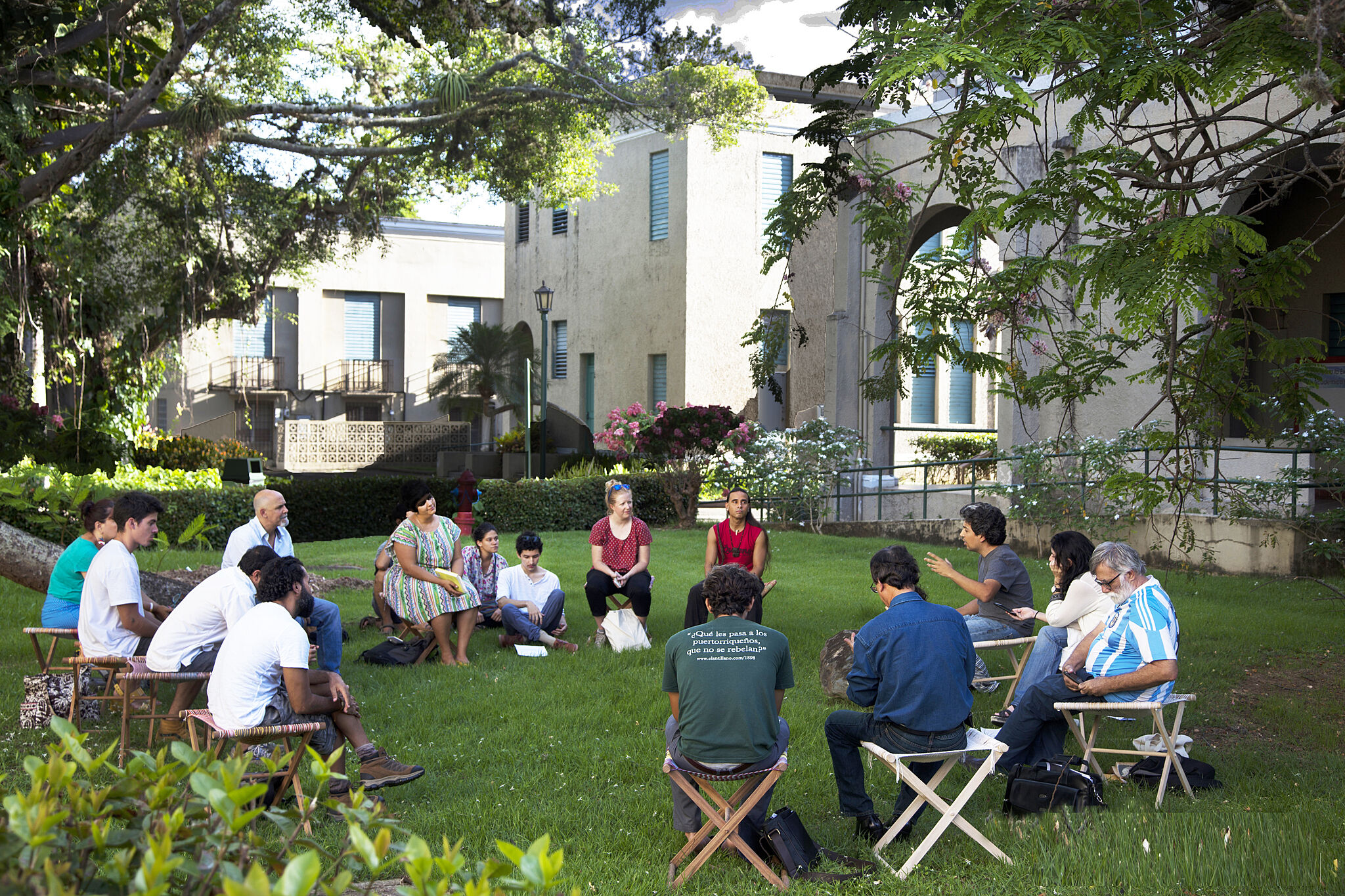 People sitting around in a circle on a lawn.