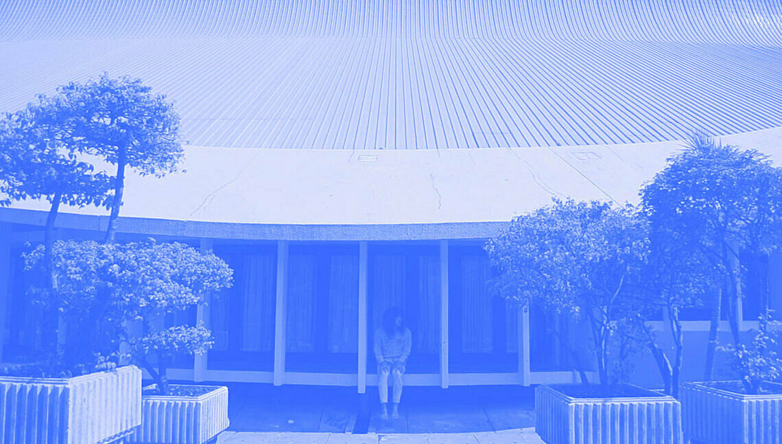 A man sitting in a large building. 