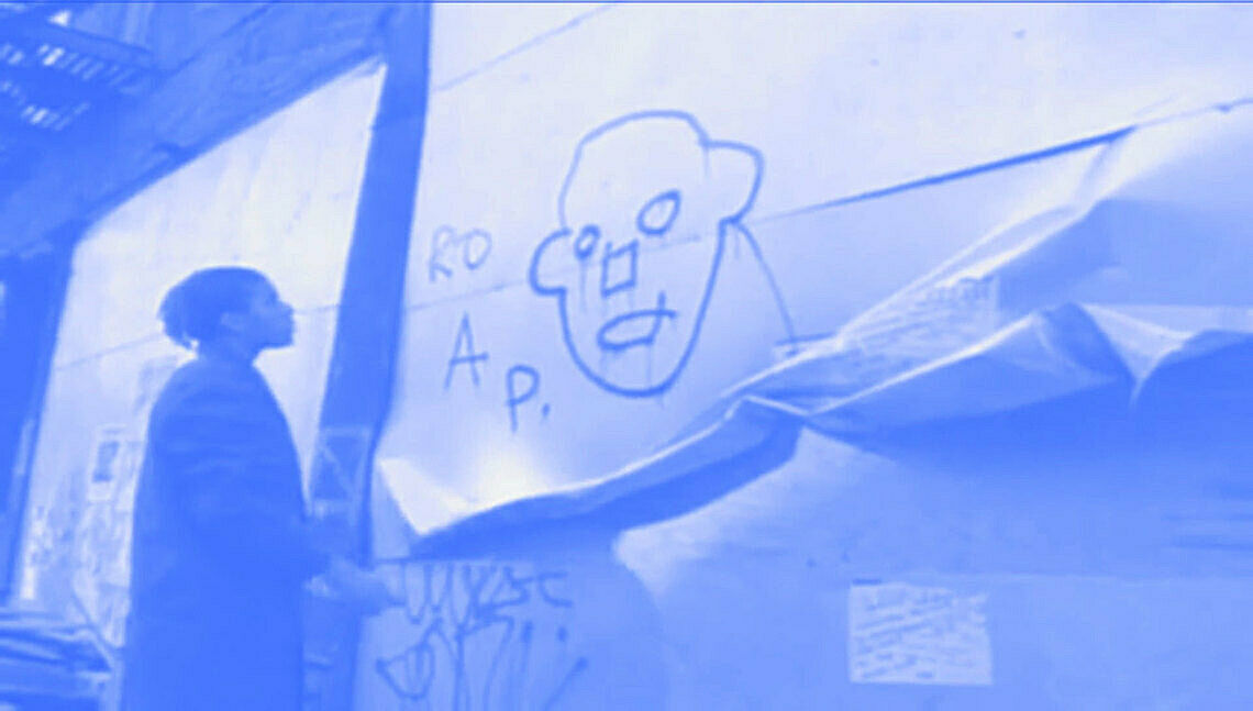 A person doodling on a wall board. 