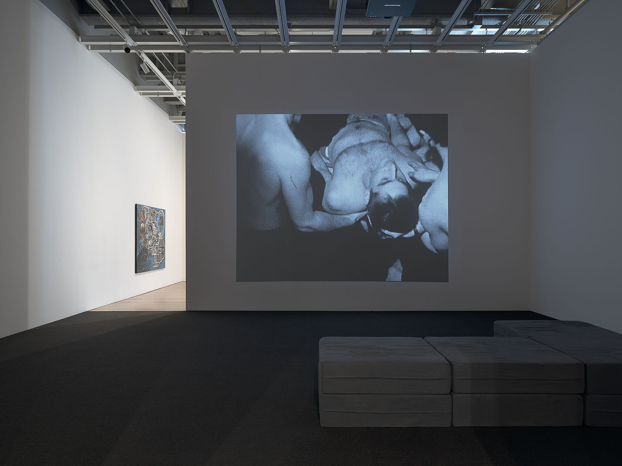 An image of the Whitney galleries with a video projected on the wall