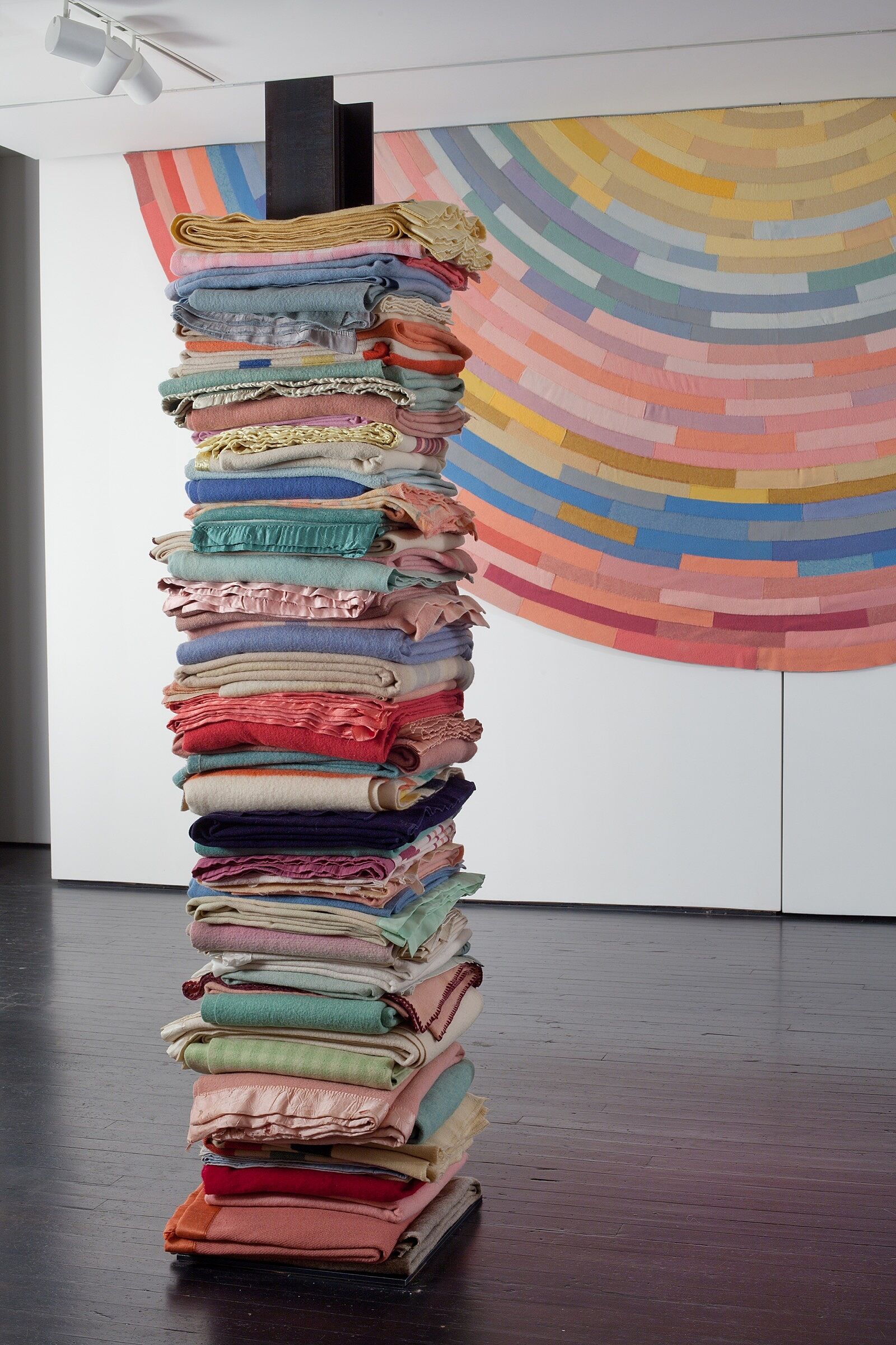 A large stack of multi-colored blankets.