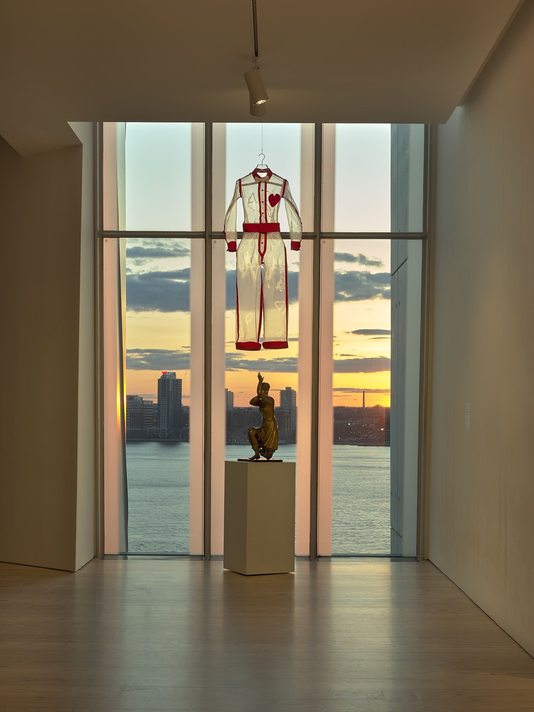 A sheer white costume hanging in front of a window.