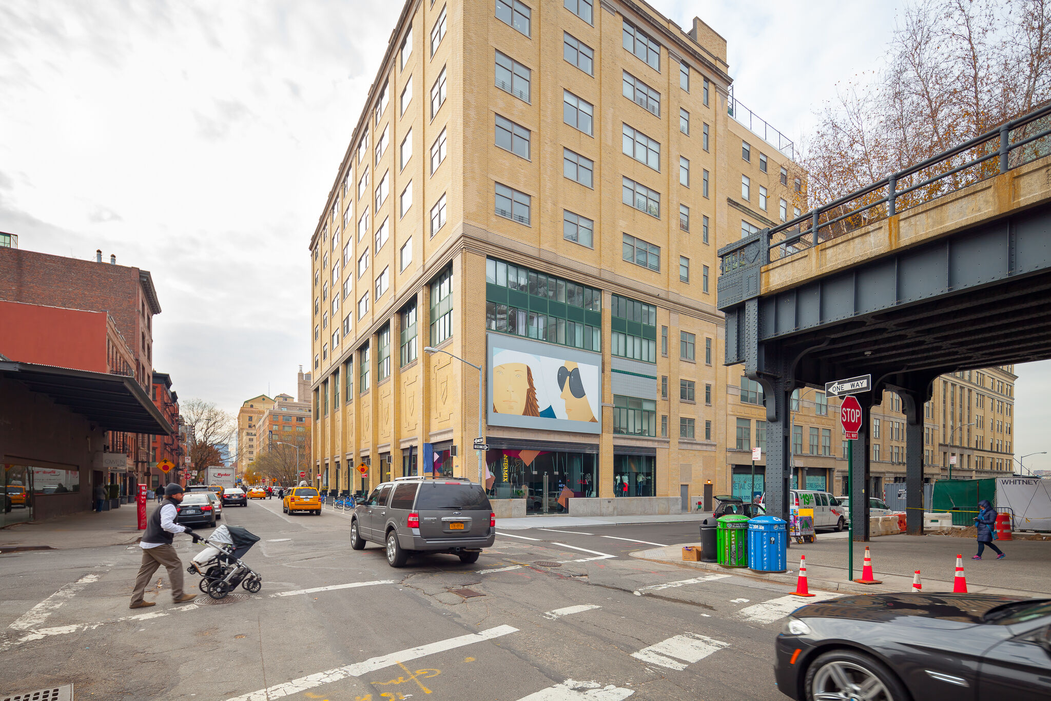 A New York City street with a view of a billboard in the background.