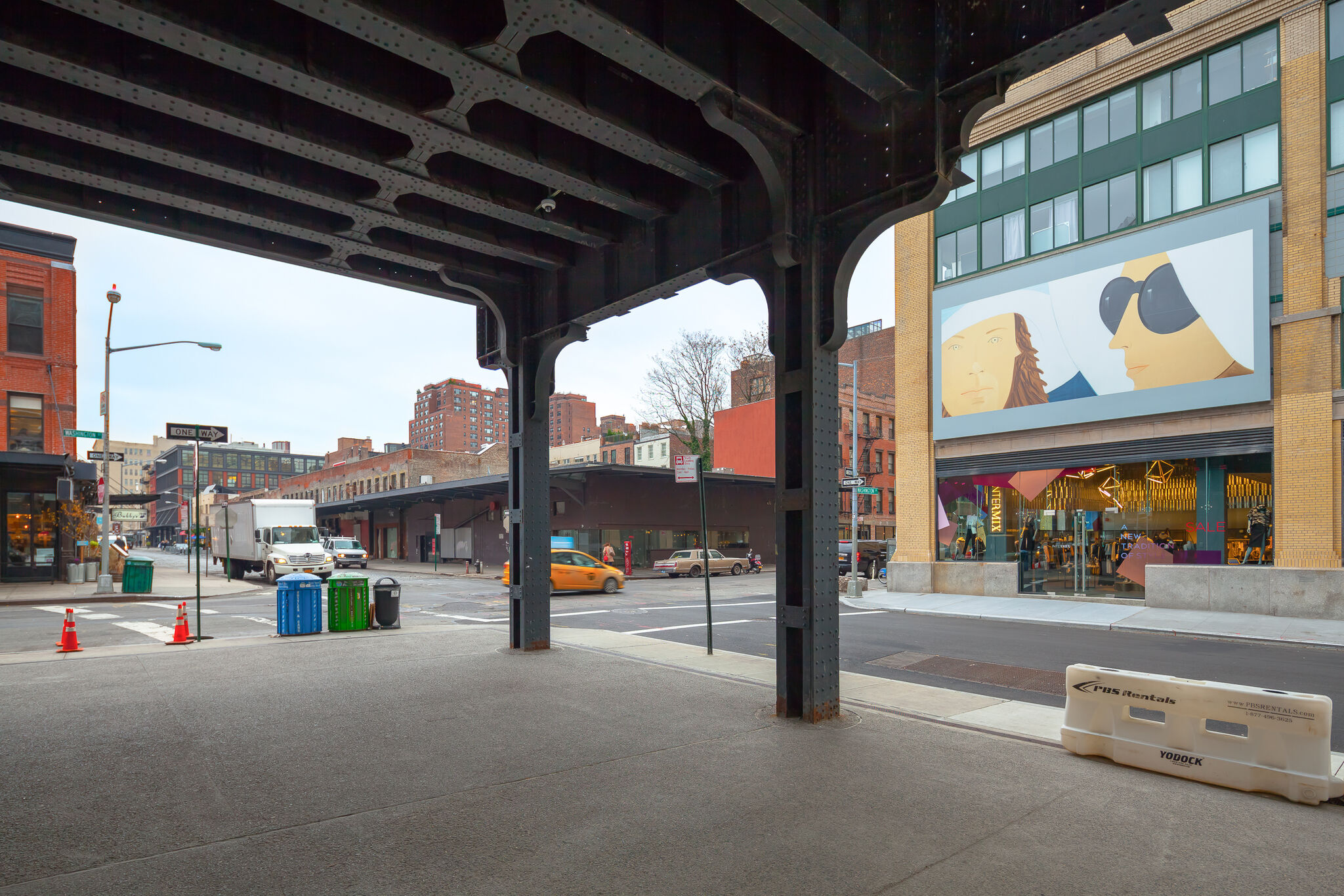 A New York City street with a billboard displayed on a building at the right.