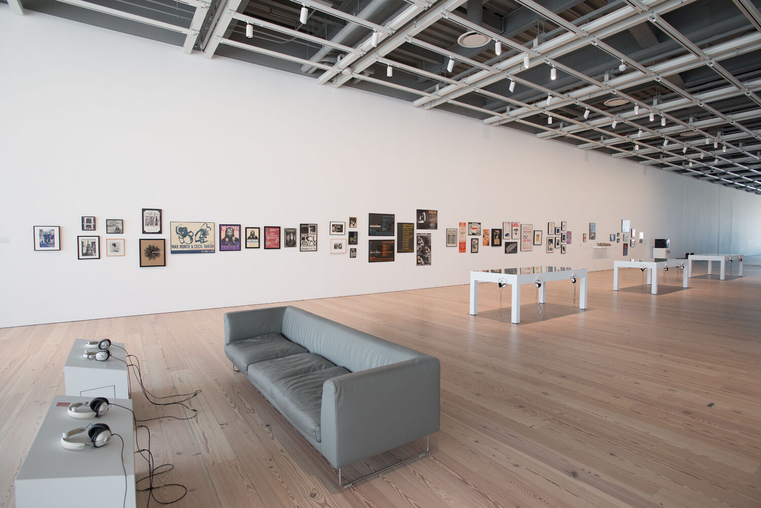 A gallery with a couch and art on the wall.