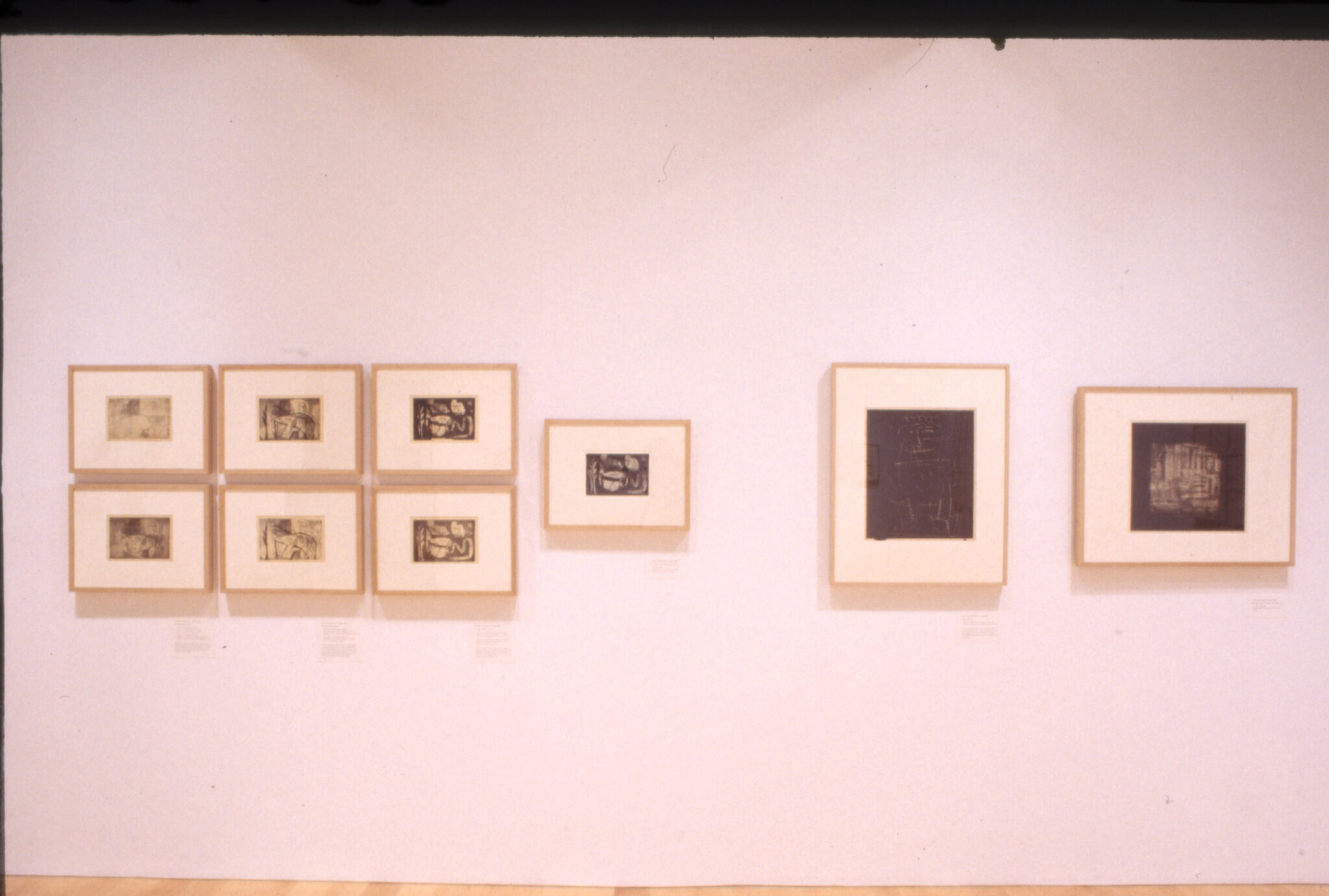 Prints displayed in frames on a wall in a gallery.